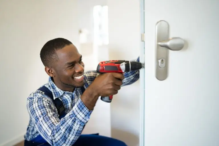 A reliable locksmith installs a door lock.