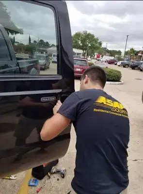 Professional locksmith providing emergency car lockout service for black vehicle