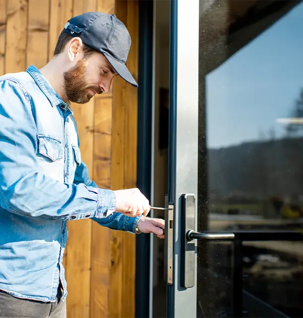 Locksmith installing new lock on commercial storefront door